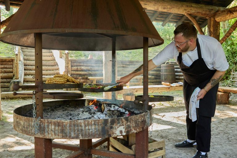 a chef cooking at a bbq hut at wildshark vineyard in kent